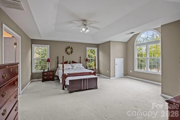 a spacious bedroom with a bed and a chandelier