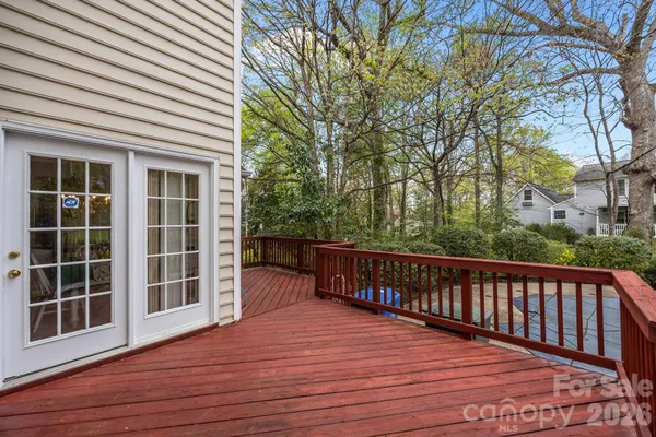 a view of balcony with wooden floor and fence and a trees
