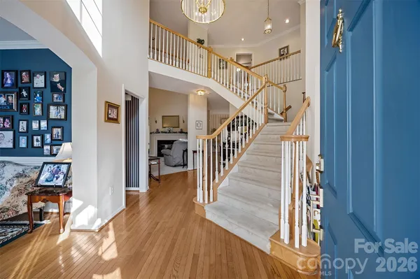 a view of a hallway with wooden floor and staircase