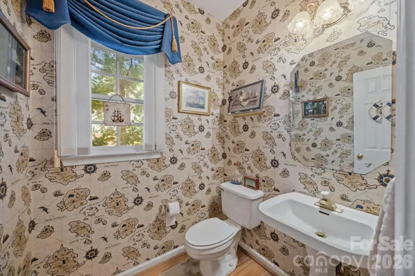 a bathroom with a sink a toilet and a mirror
