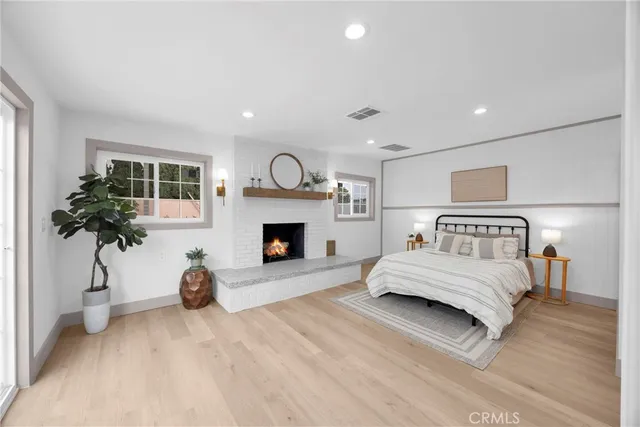 a spacious bedroom with a large bed and a potted plant