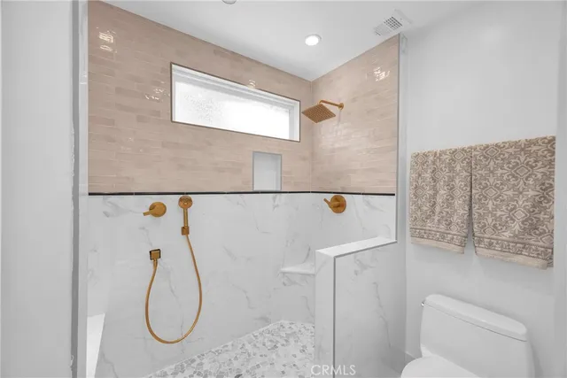 a bathroom with a toilet and a shower