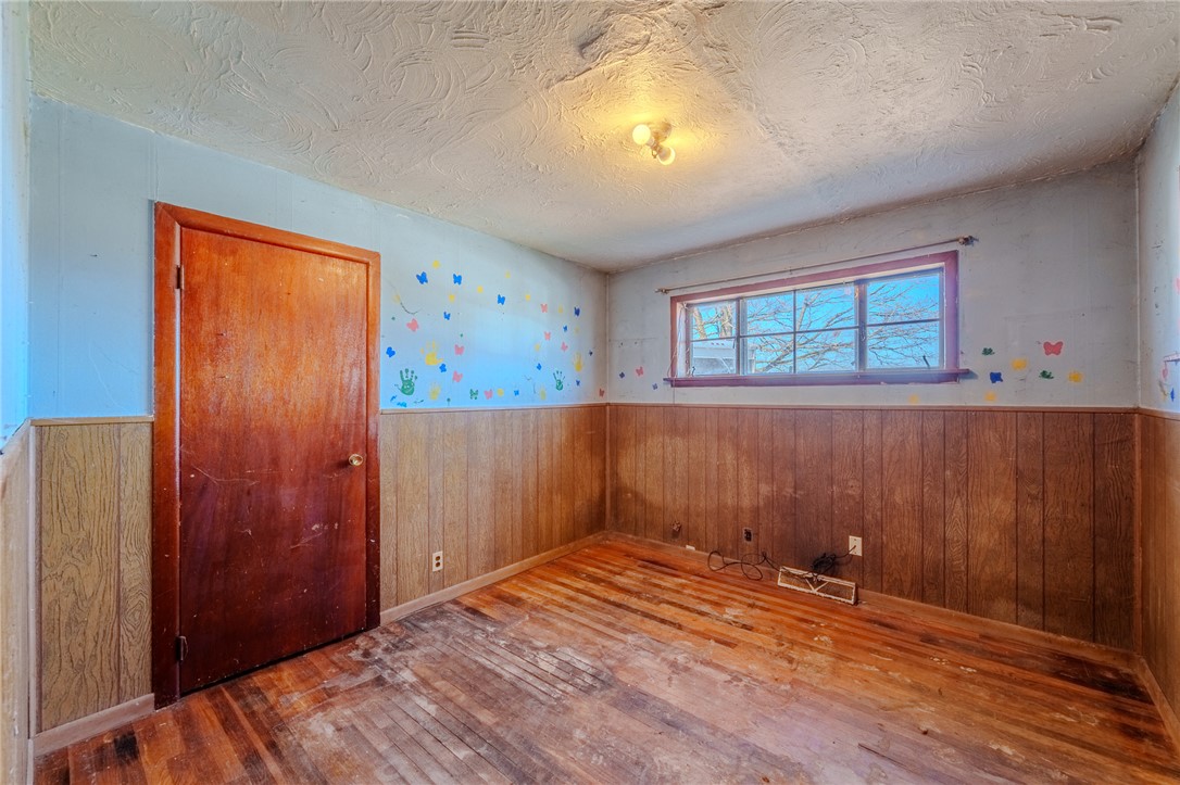 7315 Franklin-Trenton Road Franklin, OH 45005 - Photo 8 of 15 This cozy room offers hardwood flooring, a bright window, and warm wood paneling, ready for your personal touch.