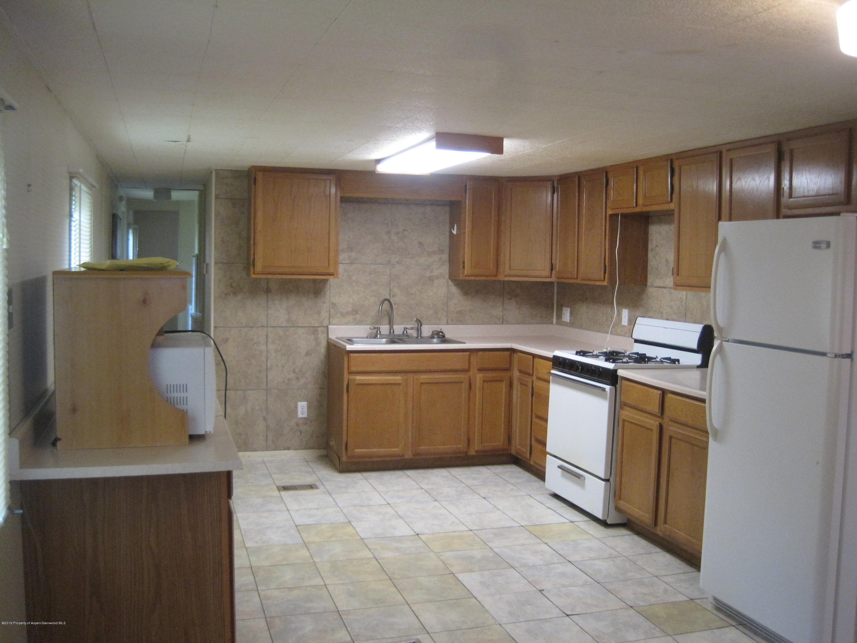 314 Highway 325 Rifle, CO 81650 - Photo 8 of 14 a kitchen with a sink a refrigerator and cabinets