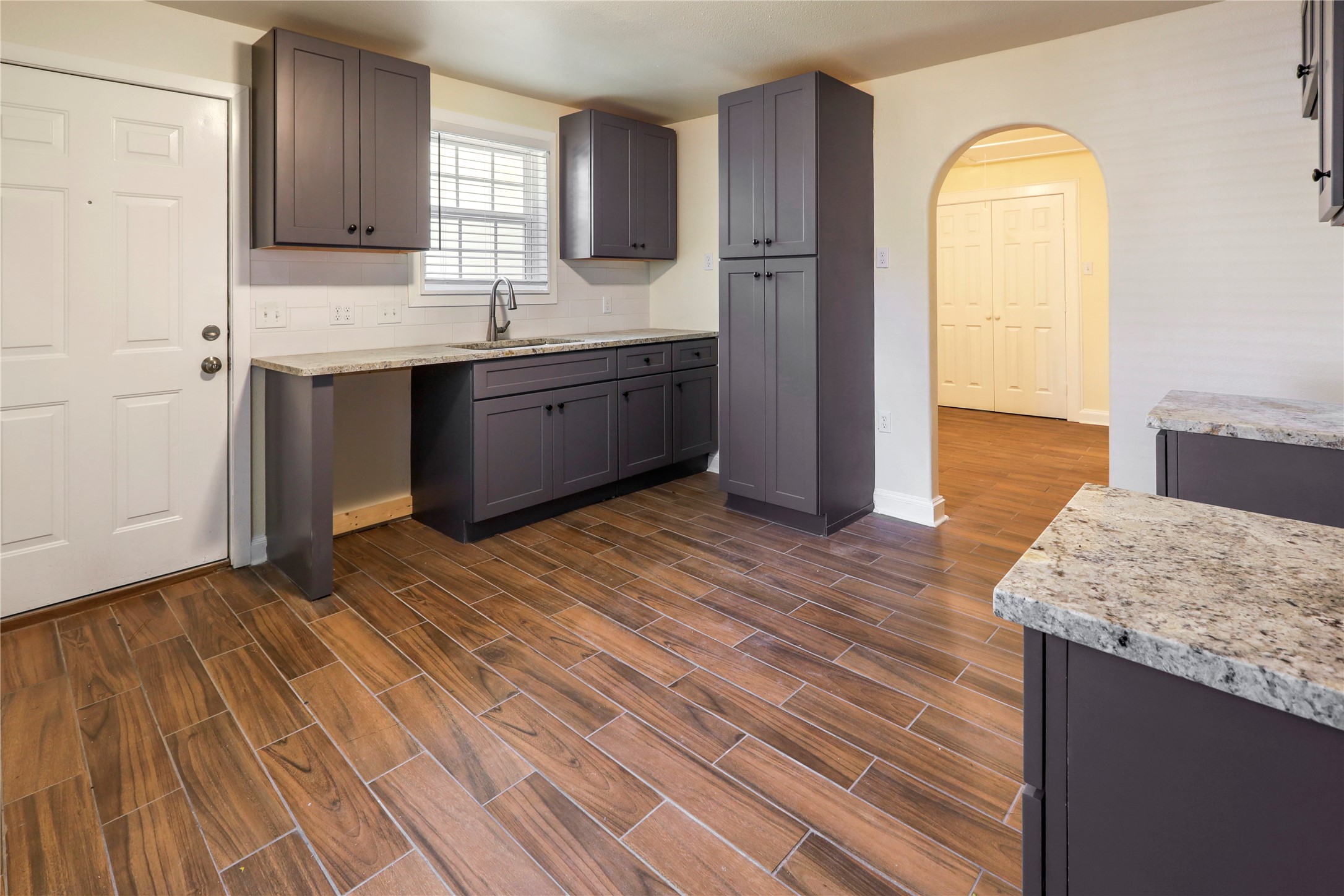 4606 Antha Street Houston, TX 77016 - Photo 14 of 27 a view of kitchen and empty room with wooden floor