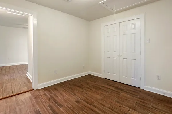 a view of an empty room with wooden floor