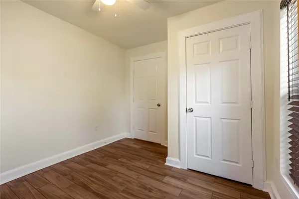 an empty room with wooden floor and closet area