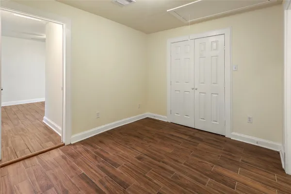 a view of an empty room with wooden floor