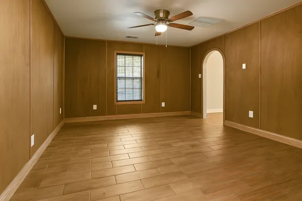 a view of an empty room with window and wooden floor