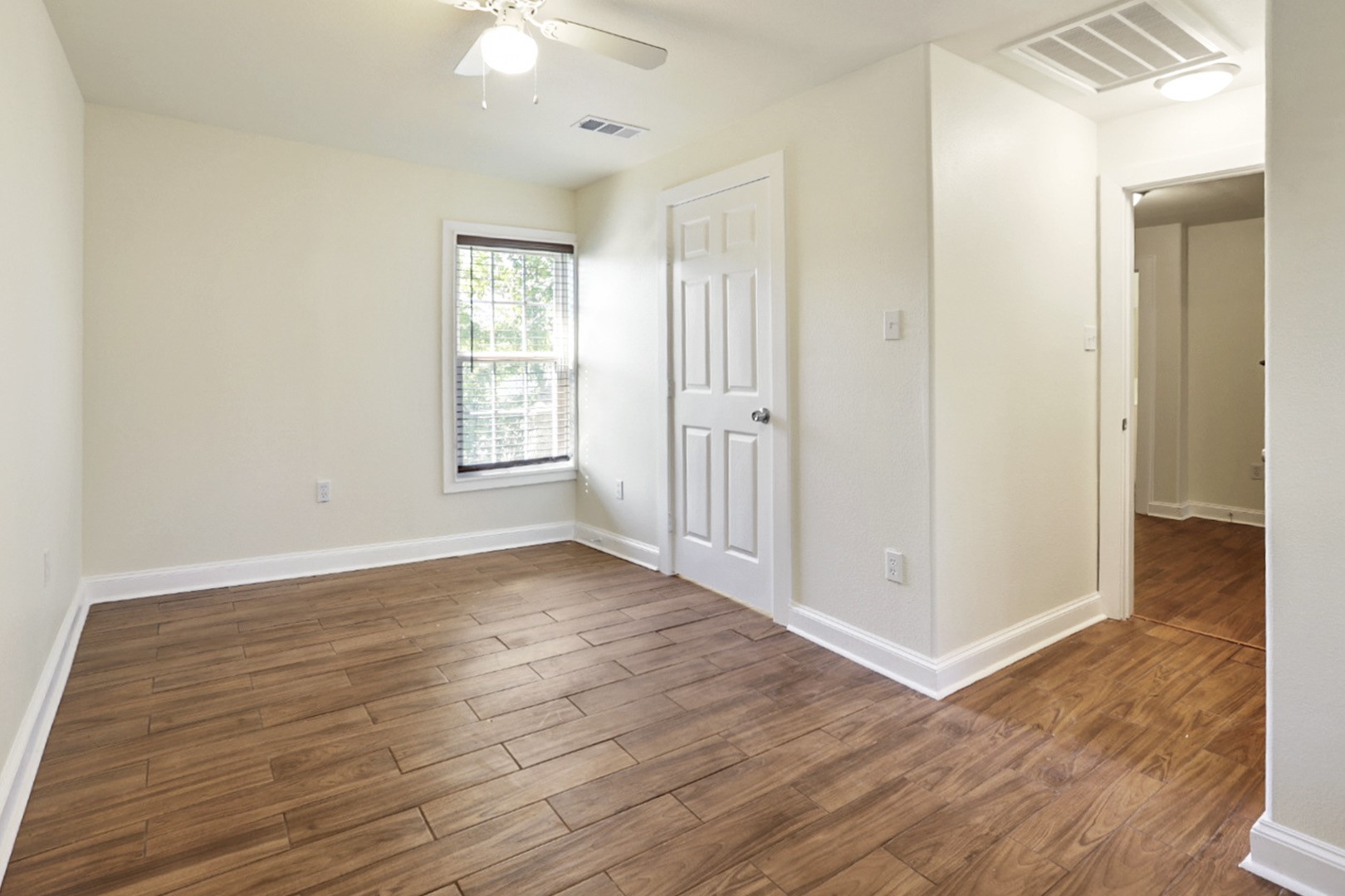 4606 Antha Street Houston, TX 77016 - Photo 7 of 27 an empty room with wooden floor and windows