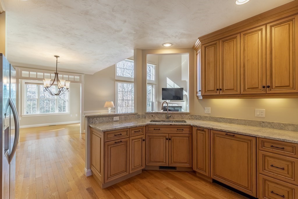22 English Commons: 12 Boston Street, Unit 22 Topsfield, MA 01983 - Photo 12 of 41 a kitchen with a sink cabinets and wooden floor