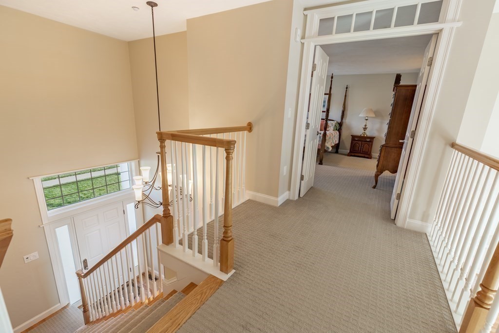 22 English Commons: 12 Boston Street, Unit 22 Topsfield, MA 01983 - Photo 19 of 41 a view of a hallway with wooden floor and windows