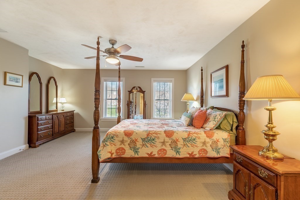 22 English Commons: 12 Boston Street, Unit 22 Topsfield, MA 01983 - Photo 21 of 41 a bedroom with a bed and a chandelier