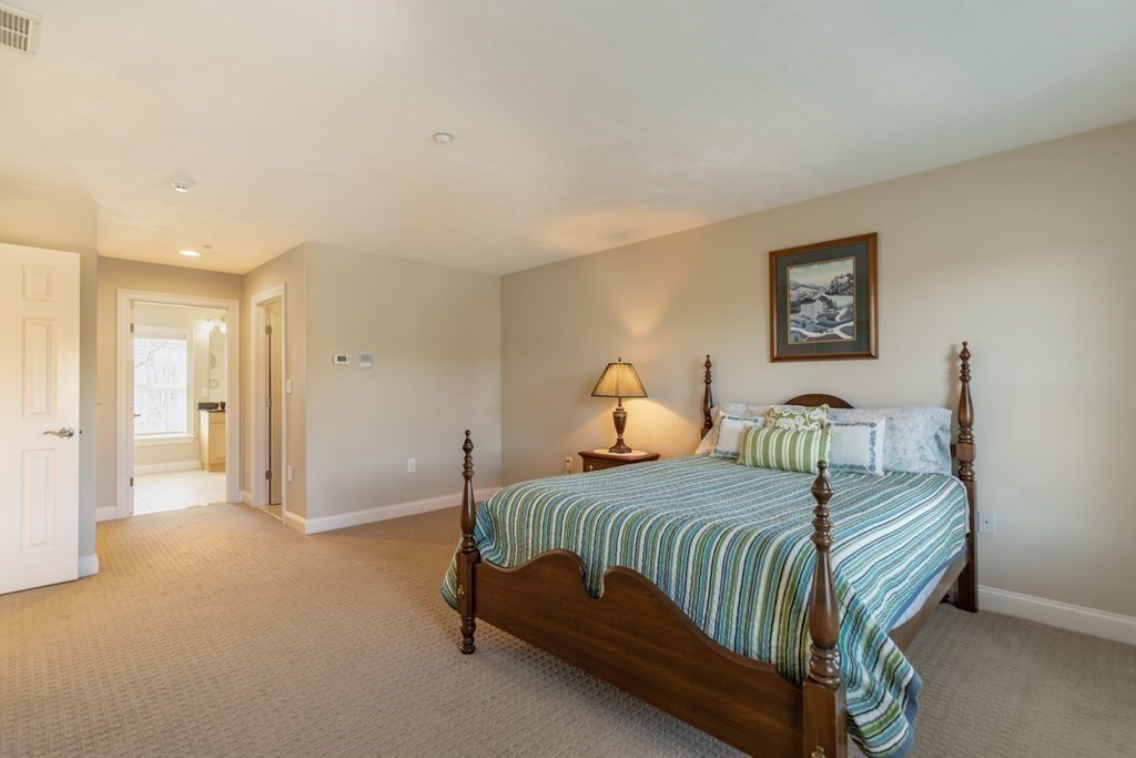 22 English Commons: 12 Boston Street, Unit 22 Topsfield, MA 01983 - Photo 24 of 41 a bedroom with a bed and a painting on the wall