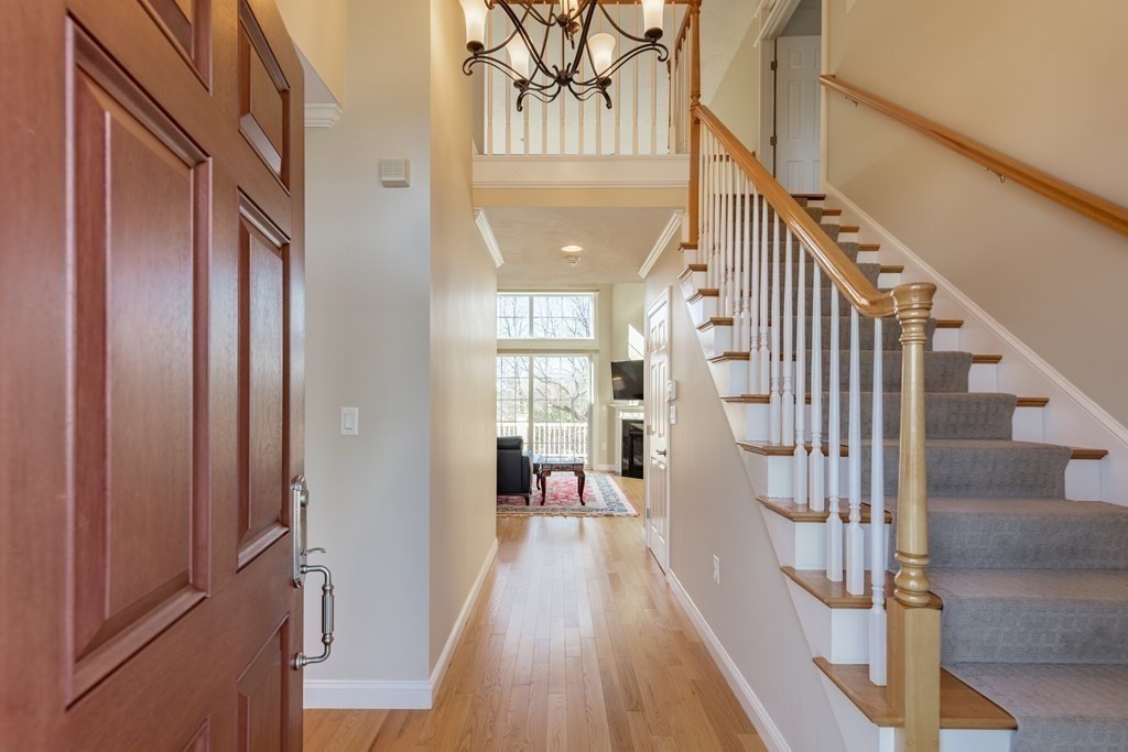22 English Commons: 12 Boston Street, Unit 22 Topsfield, MA 01983 - Photo 5 of 41 a view of a hallway with wooden floor and staircase