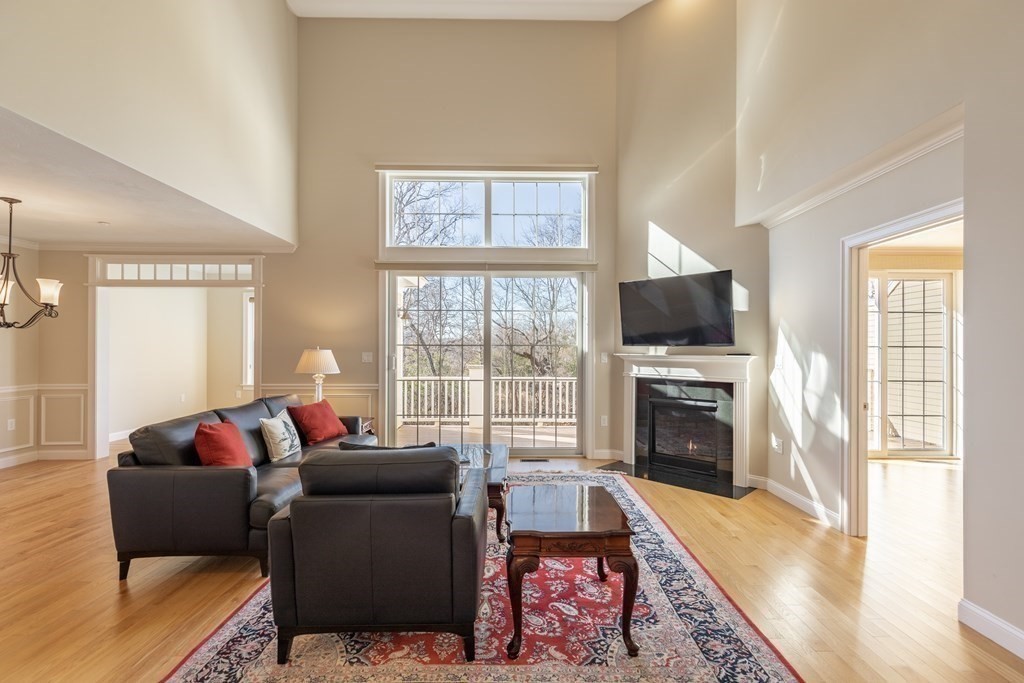 22 English Commons: 12 Boston Street, Unit 22 Topsfield, MA 01983 - Photo 6 of 41 a living room with furniture a flat screen tv and a fireplace