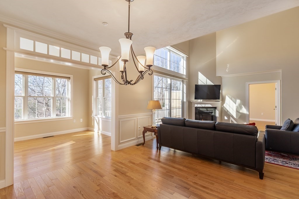 22 English Commons: 12 Boston Street, Unit 22 Topsfield, MA 01983 - Photo 10 of 41 a living room with furniture a flat screen tv and a window