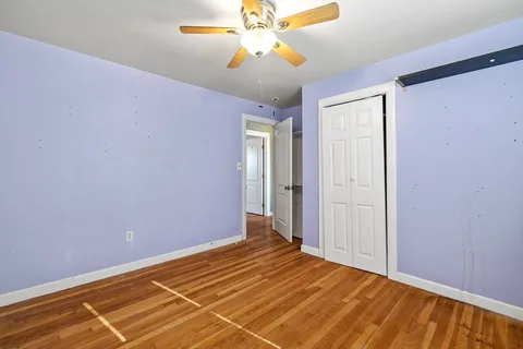 a view of a room with wooden floor and a ceiling fan