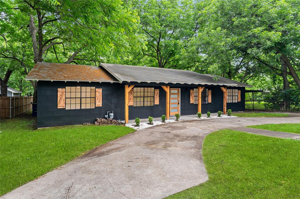110 Hackberry Street Lancaster, TX 75146 - Photo 31 of 32 Contemporary exterior with dark siding, featuring decorative wood shutters and exposed wood structural elements