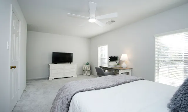 a bedroom with a large bed mirror and a window