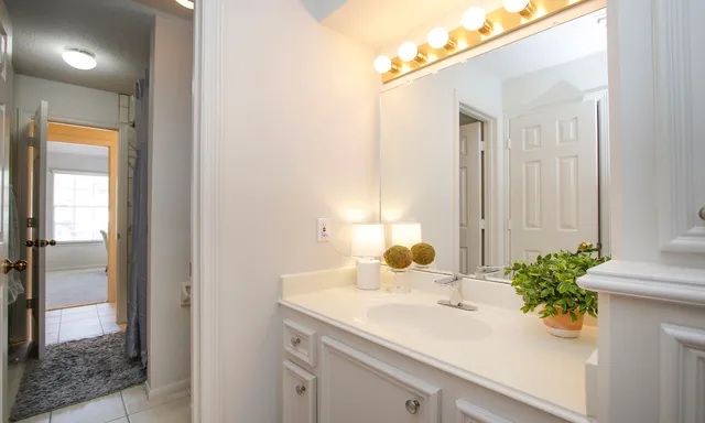 a bedroom with a bed painting on wall and a large window