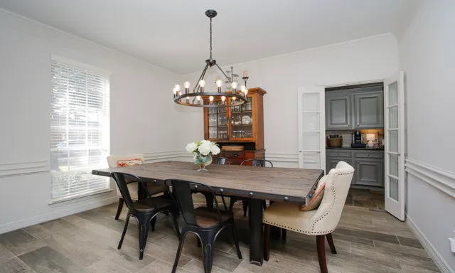 a view of a dining room with furniture a chandelier and wooden floor