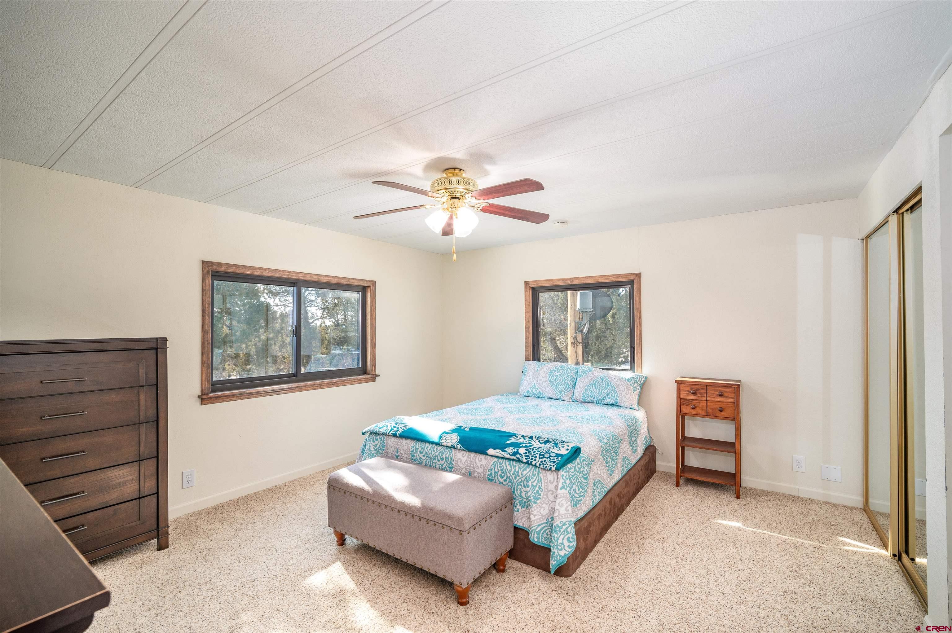 253 Valley Place Durango, CO 81303 - Photo 12 of 26 a bedroom with a bed and a chandelier