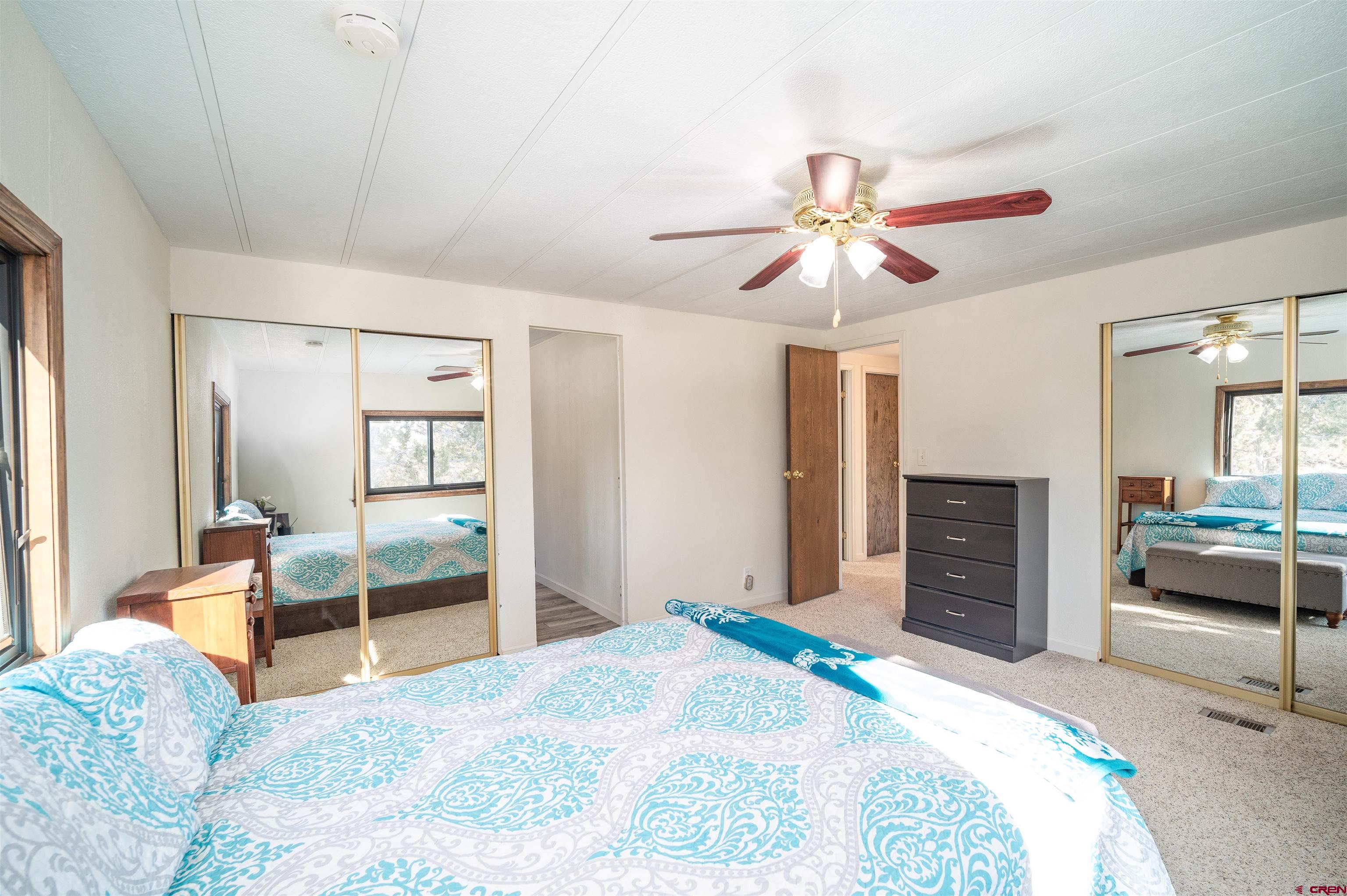 253 Valley Place Durango, CO 81303 - Photo 13 of 26 a bedroom with a bed and a chandelier