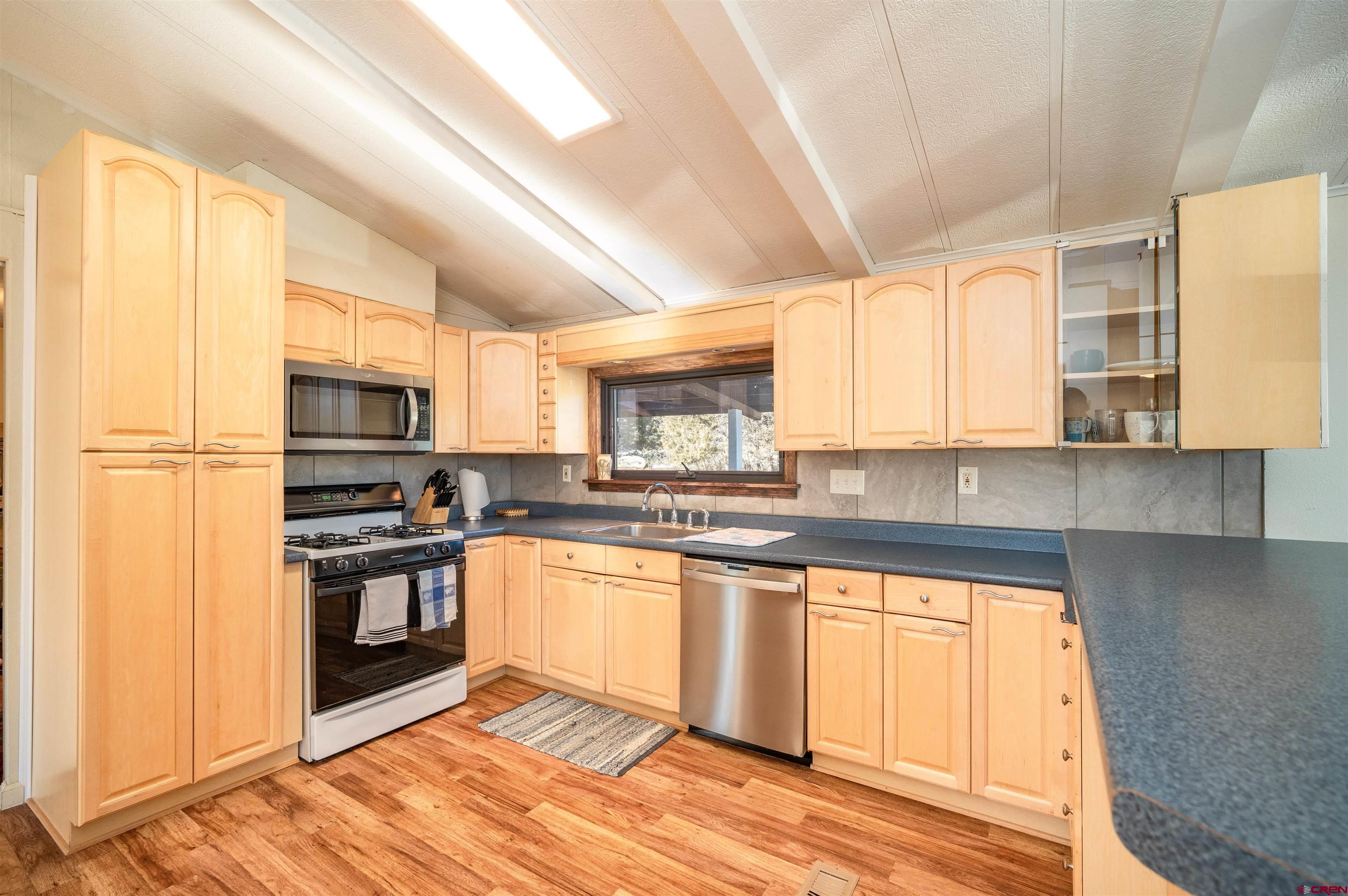 253 Valley Place Durango, CO 81303 - Photo 6 of 26 a kitchen with stainless steel appliances granite countertop a stove a sink and white cabinets