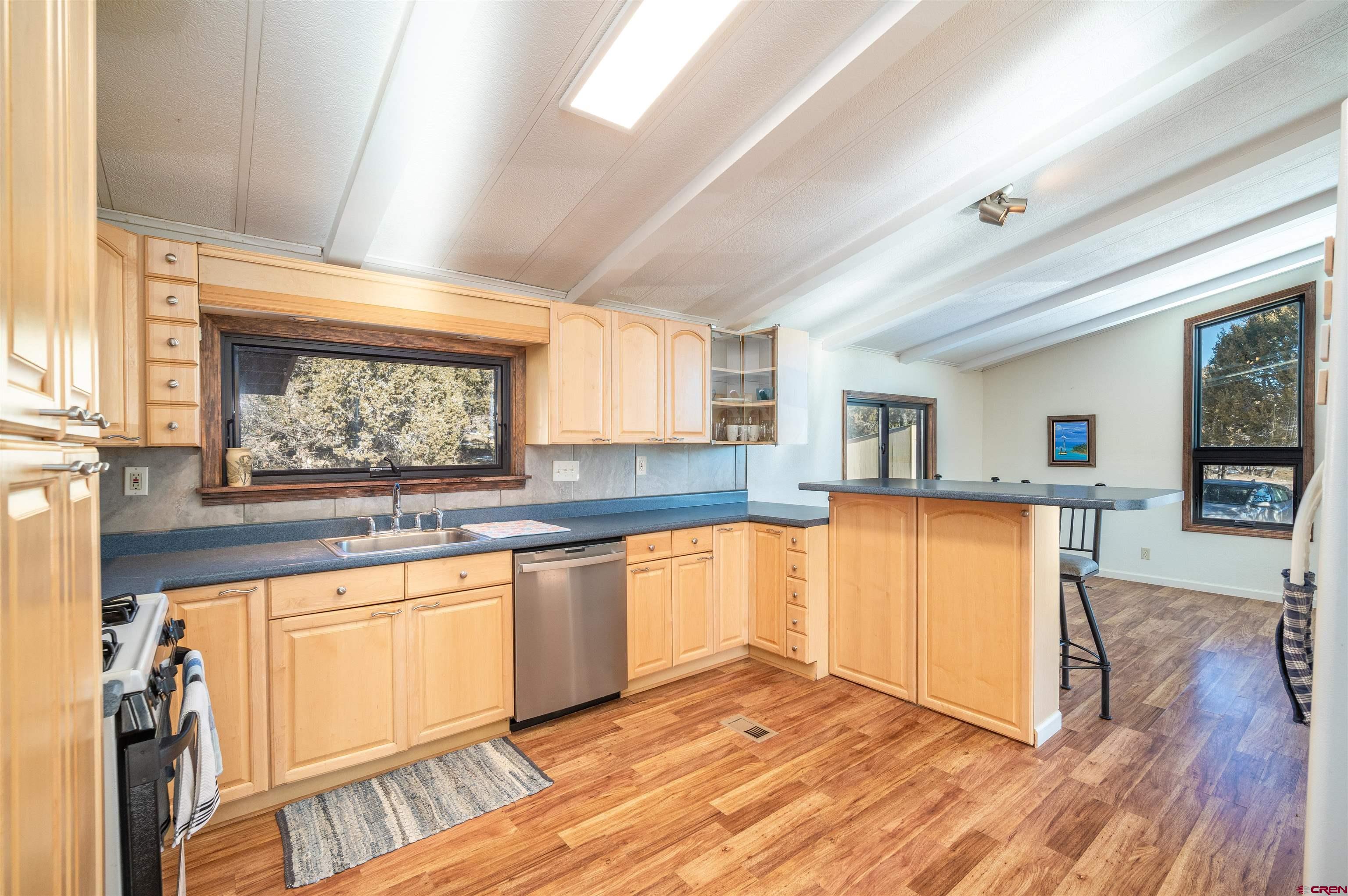 253 Valley Place Durango, CO 81303 - Photo 7 of 26 a kitchen with granite countertop a stove a sink and a microwave