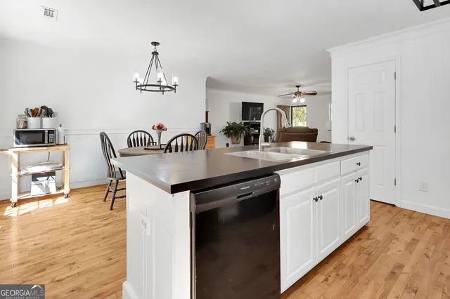 a kitchen with a sink cabinets and wooden floor