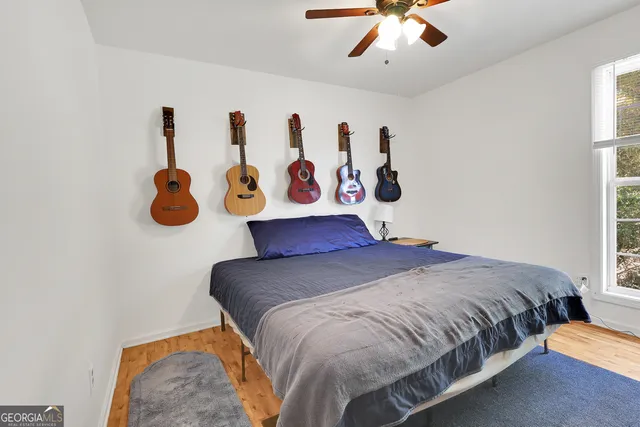 a bedroom with a bed and painting on the wall