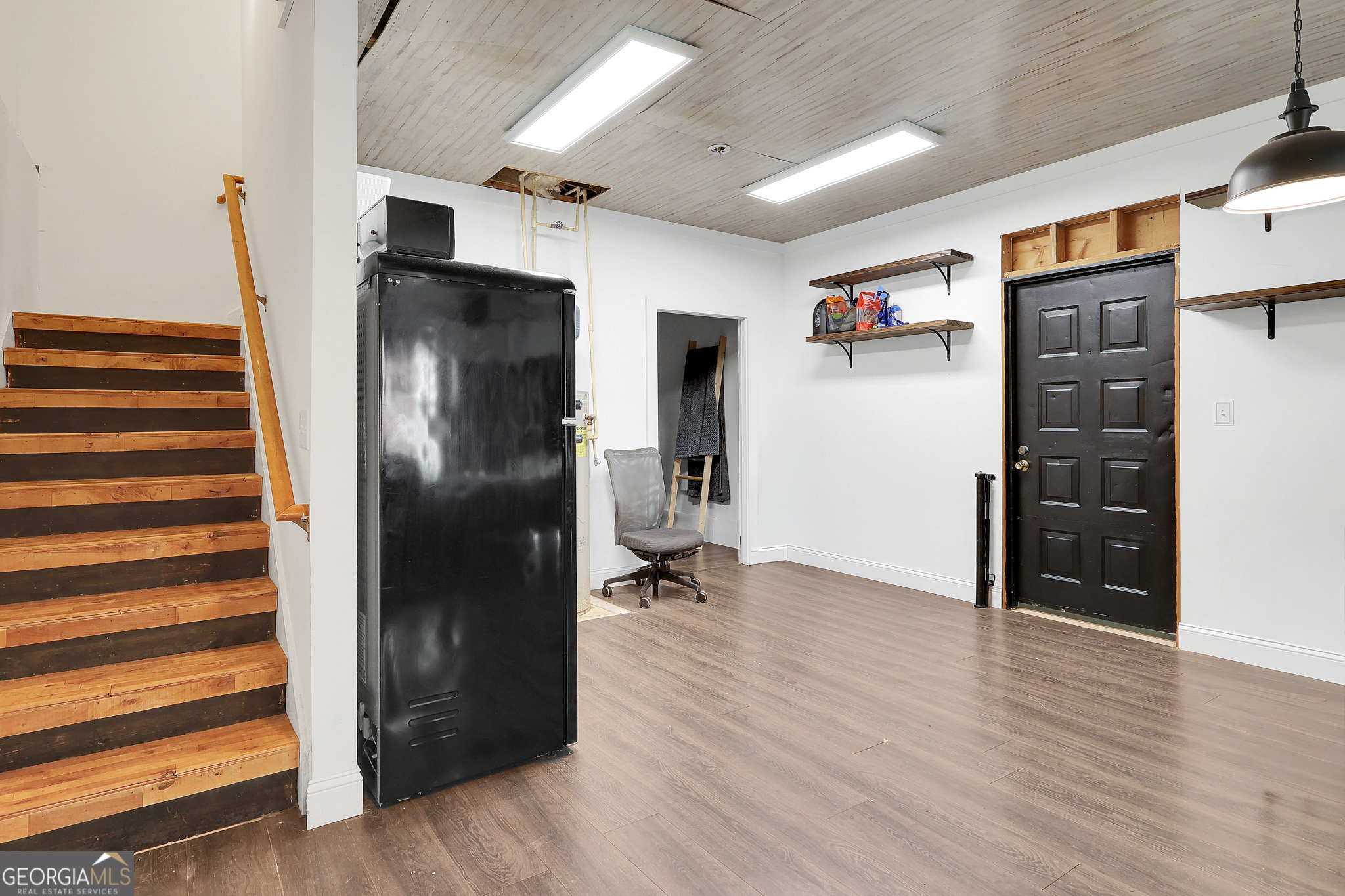 394 Burg Road Locust Grove, GA 30248 - Photo 31 of 40 a view of a refrigerator in kitchen and an empty room with wooden floor