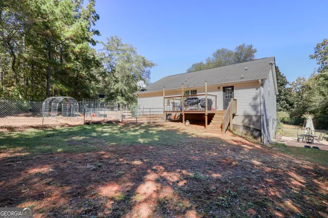 a view of a house with backyard and a tree
