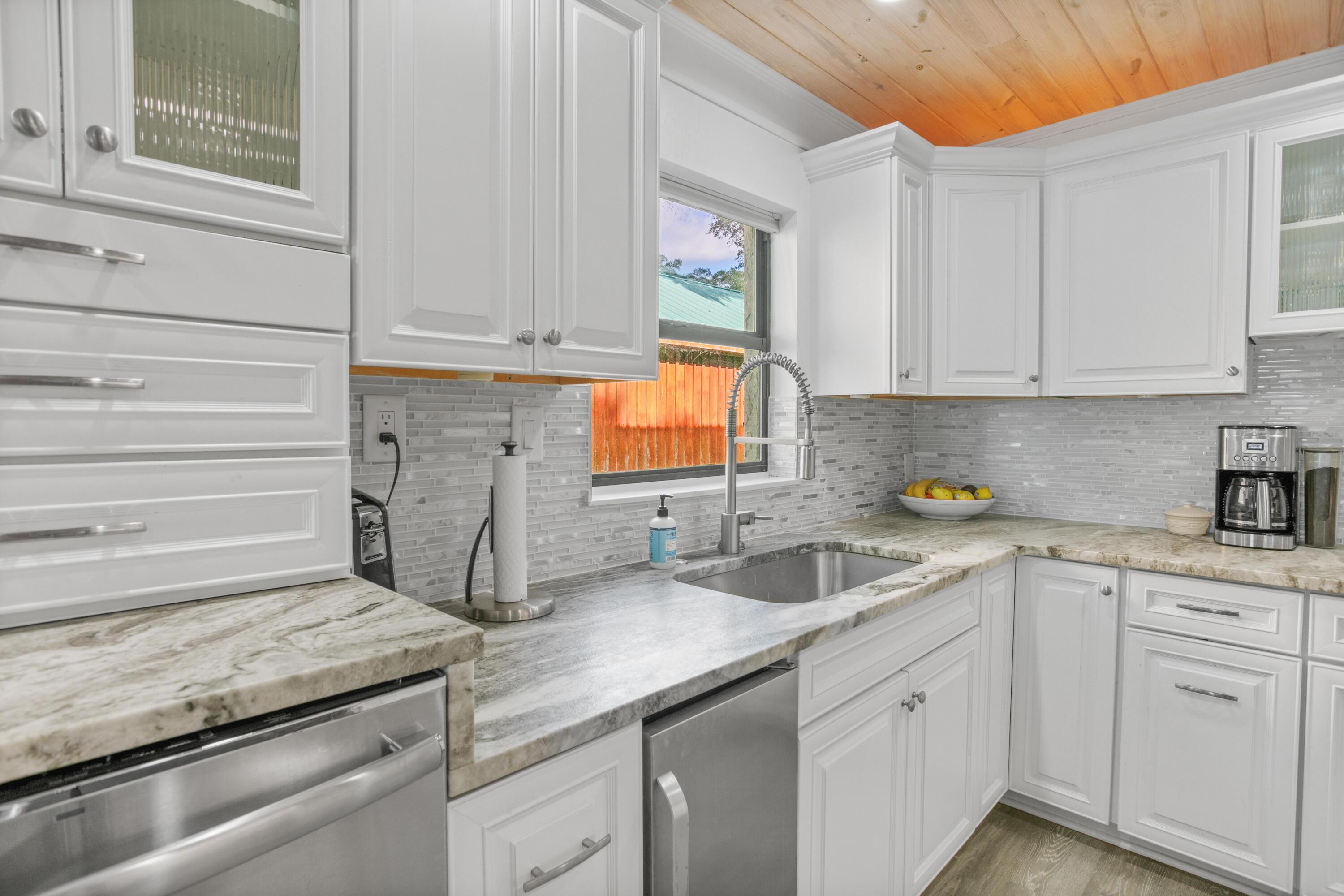 41 Waterview Place Freeport, FL 32439 - Photo 12 of 74 a kitchen with granite countertop a sink and white cabinets