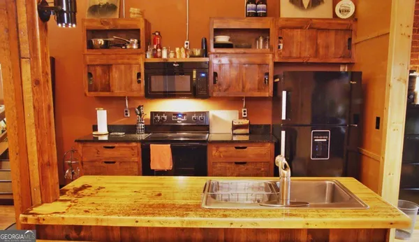 a kitchen with kitchen island granite countertop a refrigerator stove and sink