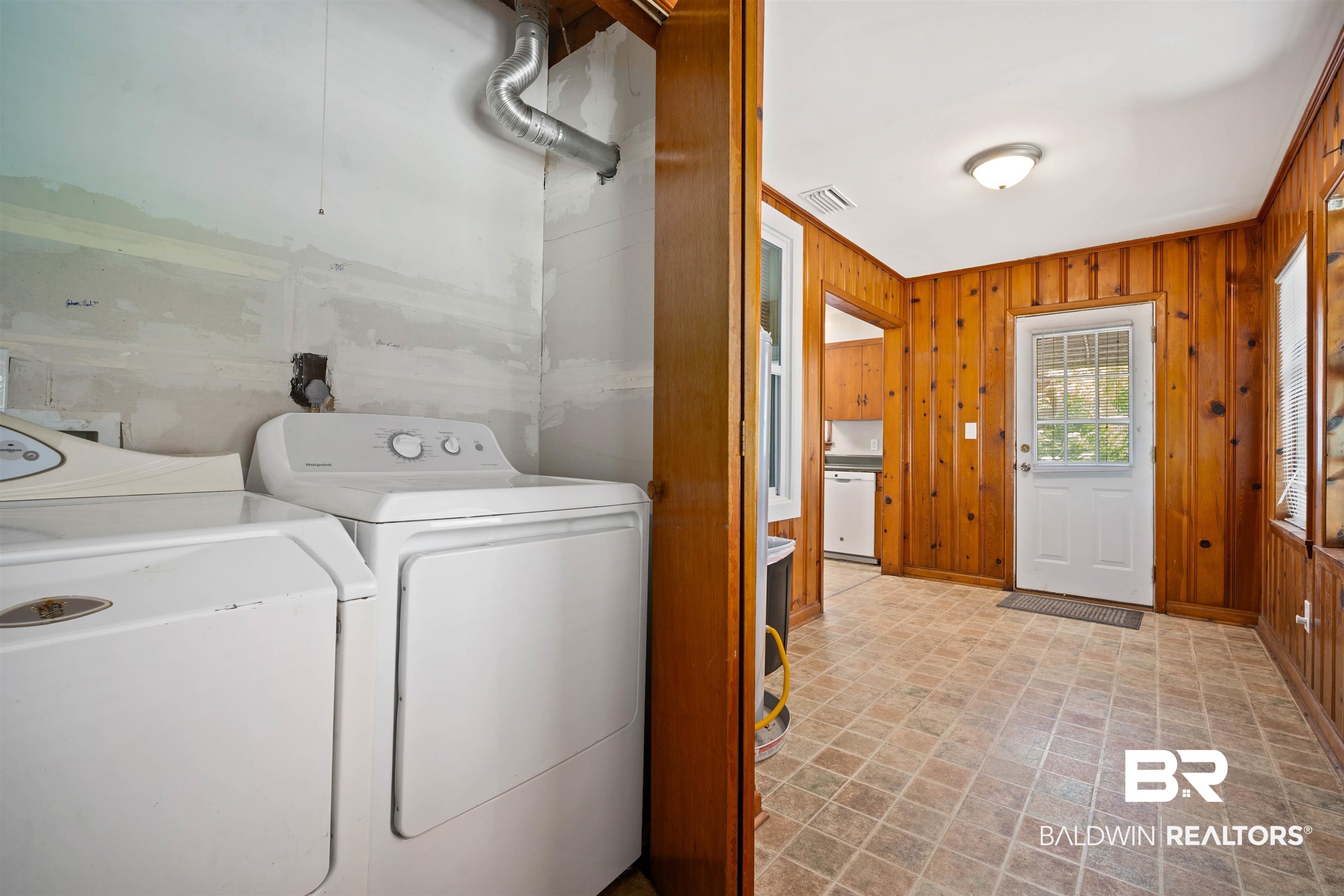 9 Elizabeth Avenue Mobile, AL 36611 - Photo 19 of 19 Laundry room featuring wood walls, independent washer and dryer, and brick patterned flooring