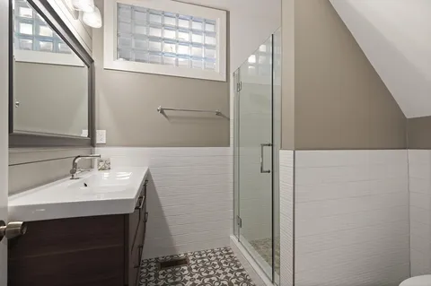 a bathroom with a sink a toilet and shower