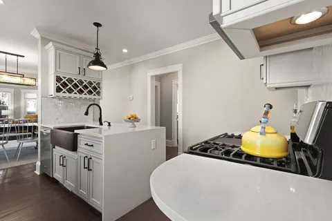 a kitchen with sink a stove and chairs