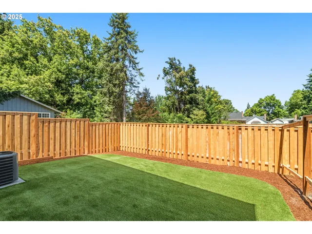 a view of a yard with wooden fence