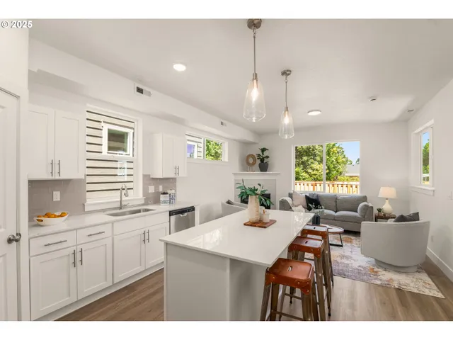 a kitchen with a sink dishwasher a stove a dining table with wooden floor