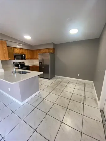 a kitchen with stainless steel appliances a sink a stove a microwave a counter top space and cabinets