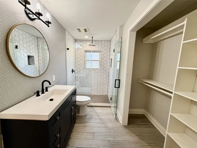 a bathroom with a sink a toilet and a mirror