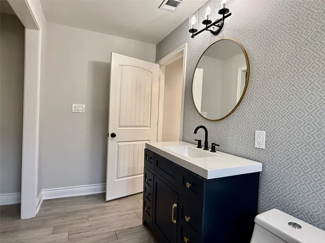a bathroom with a sink vanity and a mirror