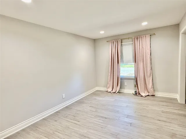 an empty room with wooden floor and door