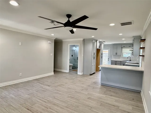 a view of a big room with wooden floor and a kitchen