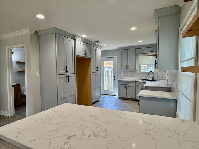 a large white kitchen with cabinets and stainless steel appliances