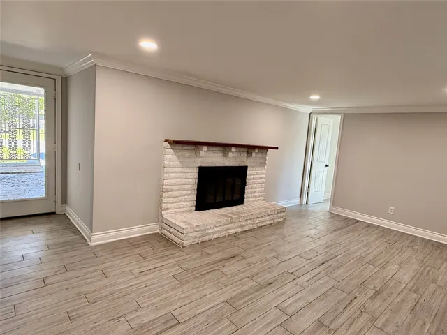an empty room with wooden floor and fireplace