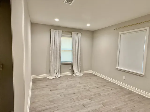 an empty room with wooden floor and a window