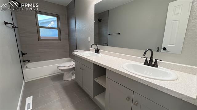 1219 Prairie Road Colorado Springs, CO 80909 - Photo 13 of 16 Full bathroom with double vanity sinks